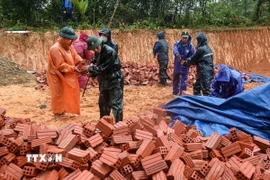 Những người lính bộ đội cụ Hồ quyết tâm “vượt nắng, thắng mưa” xây dựng lại nhà cho người dân vùng sạt lở. (Ảnh: Quốc Dũng/TTXVN)