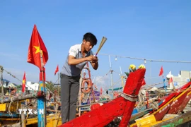 Ngư dân làm lễ "cúng thuyền", cầu yên, cầu lộc, mong biển cả mưa thuận gió hòa, tôm cá đầy khoang. (Ảnh: Xuân Tiến/TTXVN)