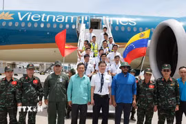 Đại diện đoàn cứu hộ Việt Nam chụp ảnh chung với đại diện lãnh đạo Venezuela và tổ bay Vietnam Airlines. (Ảnh: Phi Hùng/TTXVN)