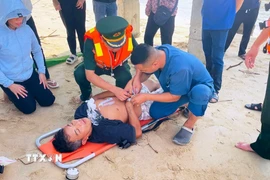Các lực lượng, đơn vị phối hợp sơ cứu ngư dân có biểu hiện xuất huyết não khi đang hành nghề trên biển. (Ảnh: Võ Dung/TTXVN)