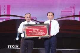 Bí thư Thành ủy TP Hồ Chí Minh Nguyễn Văn Nên trao bảng tôn vinh cho gia đình cố Thủ tướng Chính phủ Phan Văn Khải. (Ảnh: Hữu Duyên/ TTXVN)