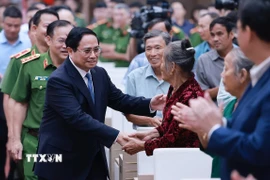 Thủ tướng Phạm Minh Chính với thân nhân liệt sỹ. (Ảnh: Dương Giang/TTXVN)