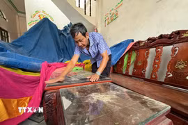 Dù đã khóa kín cửa nhưng bụi vẫn bám đầy trong nhà anh Nguyễn Thanh Liêm ở thôn Minh Tân Bắc, xã Mỏ Cày, tỉnh Quảng Ngãi. (Ảnh: Cao Nguyên/TTXVN)