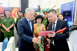 Phó Thủ tướng Thường trực Chính phủ Nguyễn Hoà Bình tham quan không gian trưng bày của Tập đoàn TH và trải nghiệm công nghệ truy xuất nguồn gốc. (Ảnh: Minh Sơn/Vietnam+)