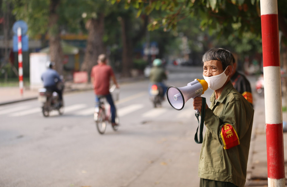 Lực lượng chức năng phường Lý Thái Tổ sử dụng loa cầm tay nhắc nhở người dân không có việc cấp thiết không ra khỏi nhà những ngày thực hiện giãn cách xã hội. (Ảnh: Anh Tuấn/TTXVN)