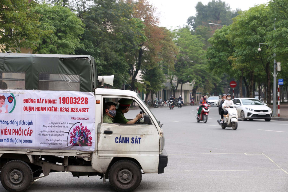 Công an quận Hoàn Kiếm sử dụng loa trên xe chuyên dụng nhắc nhở người dân Thủ đô không tập trung đông người, tập thể dục bên bờ hồ Gươm trong những ngày giãn cách xã hội. (Ảnh: Anh Tuấn/TTXVN)
