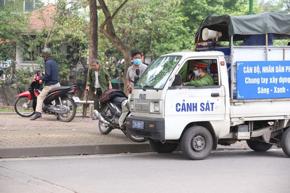 Công an phường Nguyễn Du sử dụng loa trên xe chuyên dụng nhắc nhở người dân Thủ đô không tập trung đông người, tập thể dục bên bờ hồ Thiền Quang trong những ngày giãn cách xã hội. (Ảnh: Anh Tuấn/TTXVN)
