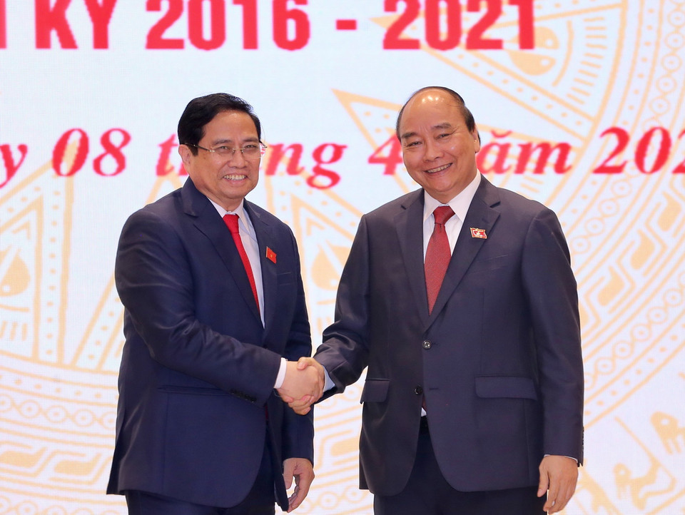  Chủ tịch nước Nguyễn Xuân Phúc, nguyên Thủ tướng Chính phủ chúc mừng Thủ tướng Chính phủ Phạm Minh Chính. Ảnh: TTXVN