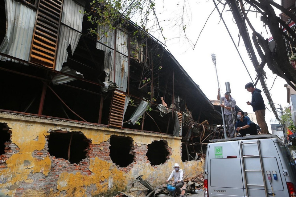 Đoàn cán bộ Chi cục Bảo vệ môi trường và Trung tâm quan trắc môi trường Hà Nội lắp đặt máy đo không khí và độ nhiễm độc tại hiện trường. (Ảnh: Thành Đạt/TTXVN)