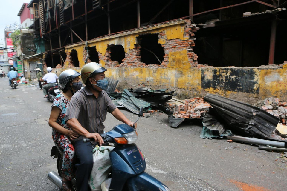 Người dân sinh sống tại đây phải đeo khẩu trang mỗi khi đi qua khu vực cháy nhà máy Bóng đèn Phích nước Rạng Đông. (Ảnh: Thành Đạt/TTXVN)