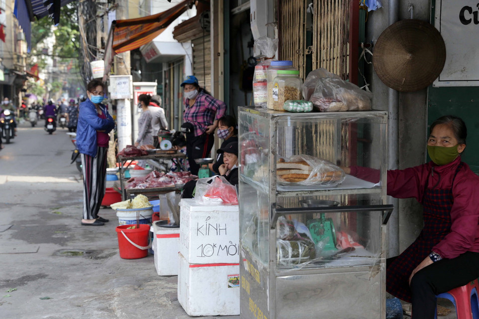 Trong những ngày qua, thành phố Hà Nội đã thực hiện nhiều biện pháp nhằm kiểm soát chặt chẽ các chợ dân sinh nhằm phòng chống dịch COVID-19, các hàng quán không phải là kinh doanh đồ thiết yếu đã không được hoạt động, các mặt hàng ăn tươi, sống vẫn được kinh doanh bình thường. Trong ảnh: Mua bán tại chợ dân sinh tự phát trên phố Lương Yên, quận Hai Bà Trưng. (Ảnh: Trần Việt/TTXVN)