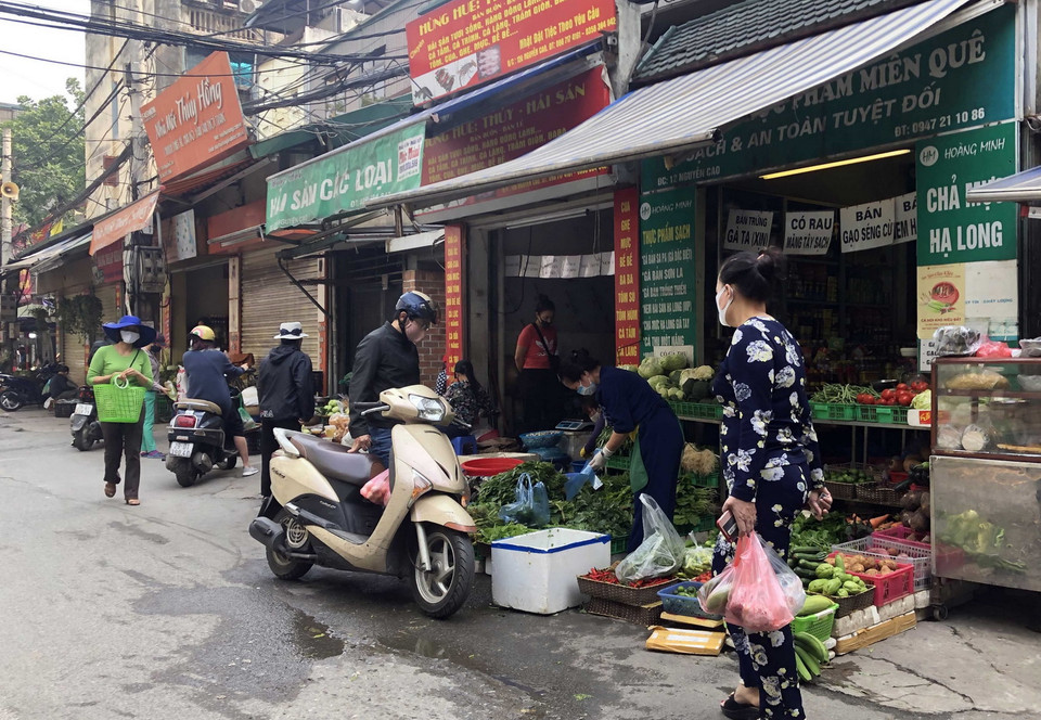 Bên cạnh việc tuyên truyền của các phương tiện thông tin đại chúng, hướng dẫn của lực lượng chức năng các cấp, người dân tham gia mua, bán tại chợ dân sinh tự phát cần tự giác chấp hành, nghiêm chỉnh thực hiện đúng quy định giãn cách góp phần chung tay vì cộng đồng trong phòng, chống đại dịch. Trong ảnh: Mua bán tại chợ dân sinh tự phát trên phố Nguyễn Cao, quận Hai Bà Trưng. (Ảnh: Trần Việt/TTXVN)