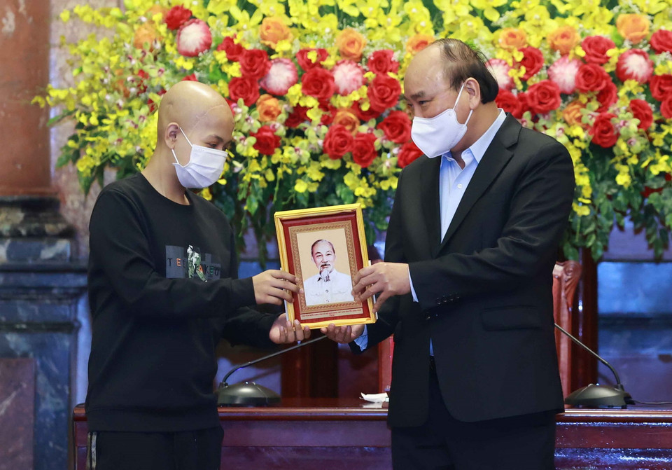 Chủ tịch nước Nguyễn Xuân Phúc tặng chân dung Chủ tịch Hồ Chí Minh cho các học sinh. (Ảnh: Thống Nhất/TTXVN)