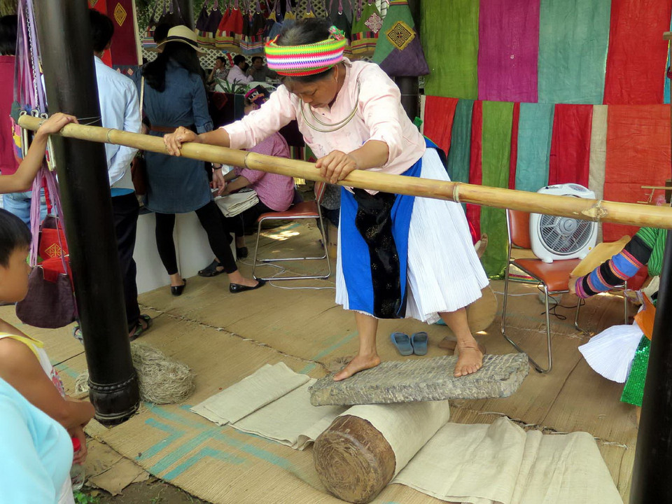 Trình diễn công đoạn làm mịn vải lanh của người Mông tại Festival. (Ảnh: Quốc Việt/TTXVN)