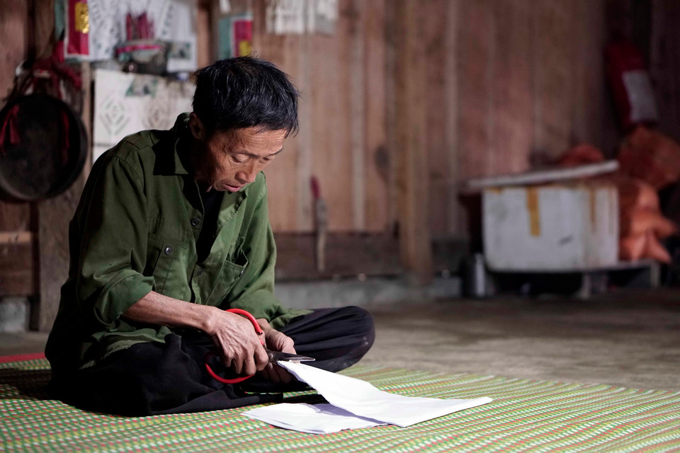 Nghi thức cắt giấy để dán lên các công cụ lao động của người Mông. Các cô gái người Mông ở xã Hồng Ngài, huyện Bắc Yên tham gia trò chơi ném pa pao. (Ảnh: Hữu Quyết/TTXVN)