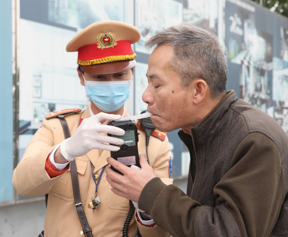 Cảnh sát giao thông Hà Nội sử dụng phương tiện an toàn kiểm tra nồng độ cồn trong khí thở đối với người tham gia giao thông. (Ảnh: Doãn Tấn/TTXVN)