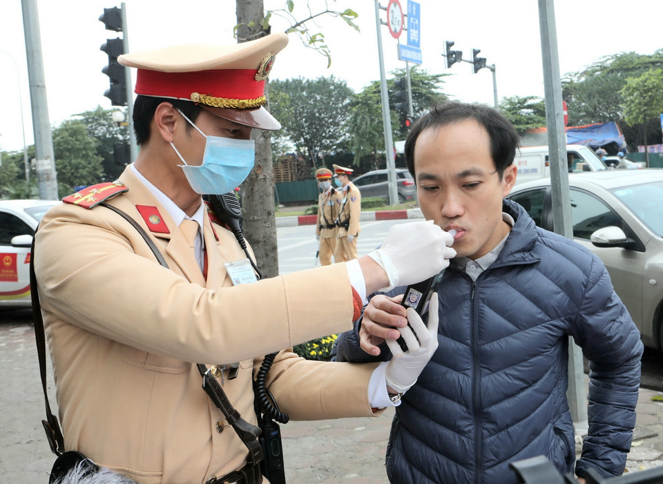 Cảnh sát giao thông Hà Nội sử dụng phương tiện an toàn kiểm tra nồng độ cồn trong khí thở đối với người tham gia giao thông. (Ảnh: Doãn Tấn/TTXVN)
