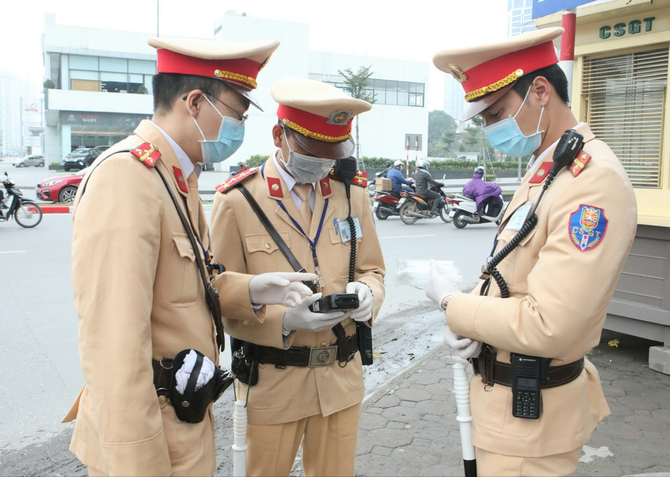 Cảnh sát giao thông Hà Nội kiểm tra trang thiết bị sử dụng phương tiện an toàn kiểm tra nồng độ cồn trong khí thở đối với người tham gia giao thông. (Ảnh: Doãn Tấn/TTXVN)