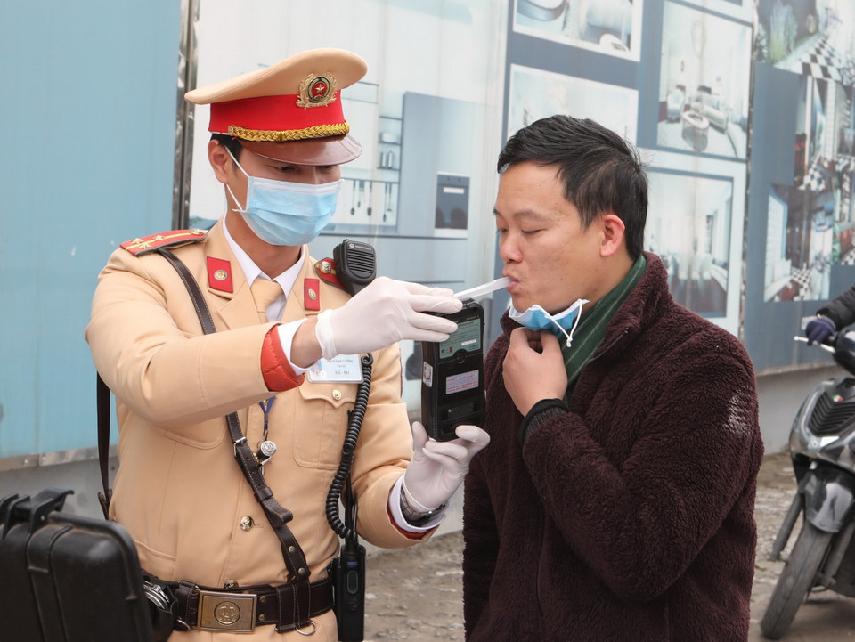 Cảnh sát giao thông Hà Nội sử dụng phương tiện an toàn kiểm tra nồng độ cồn trong khí thở đối với người tham gia giao thông. (Ảnh: Doãn Tấn/TTXVN)