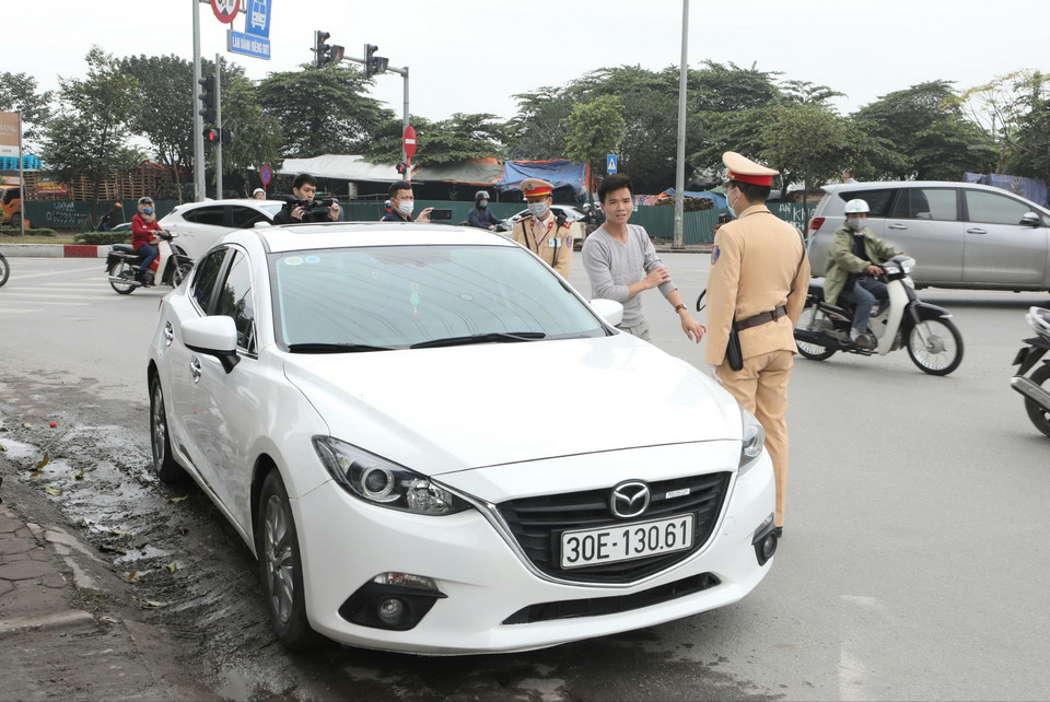 Cảnh sát giao thông Hà Nội tiến hành dừng phương tiện, sử dụng thiết bị an toàn kiểm tra nồng độ cồn trong khí thở đối với người tham gia giao thông. (Ảnh: Doãn Tấn/TTXVN)