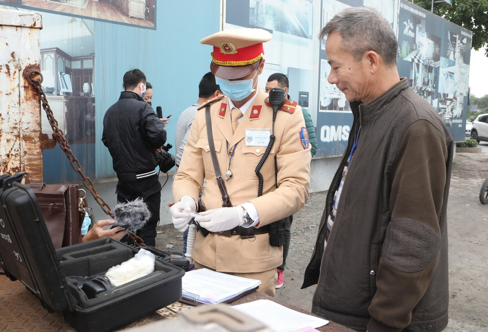 Cảnh sát giao thông Hà Nội sử dụng phương tiện an toàn kiểm tra nồng độ cồn trong khí thở đối với người tham gia giao thông. (Ảnh: Doãn Tấn/TTXVN)