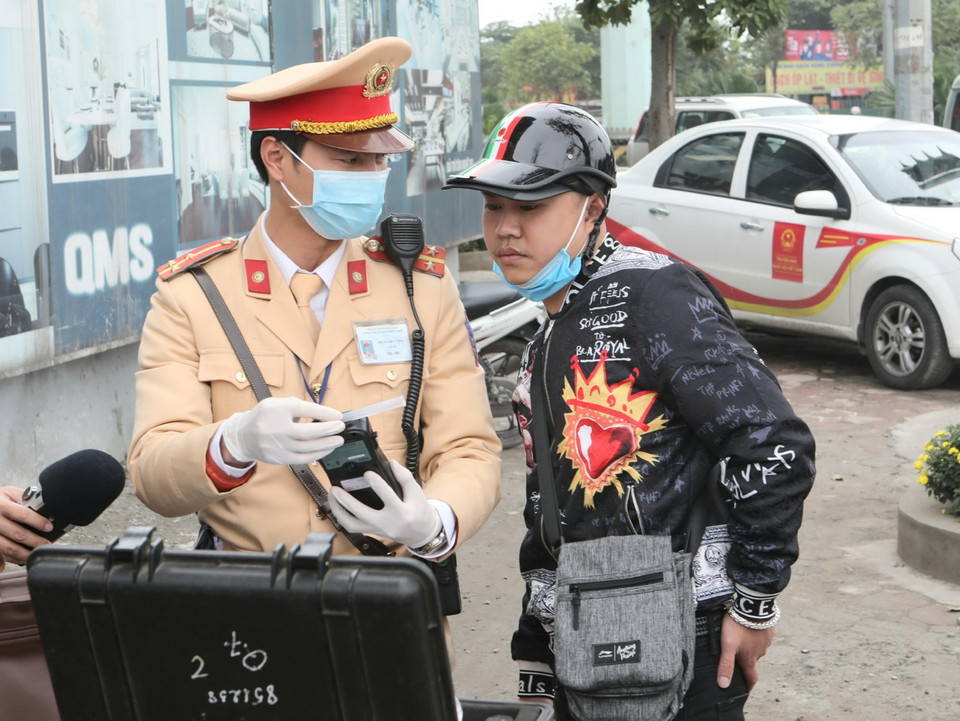 Cảnh sát giao thông Hà Nội sử dụng phương tiện an toàn kiểm tra nồng độ cồn trong khí thở đối với người tham gia giao thông. (Ảnh: Doãn Tấn/TTXVN)