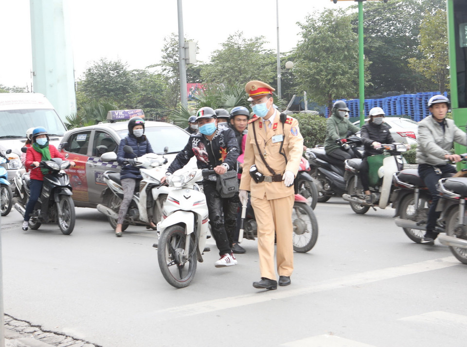 Cảnh sát giao thông Hà Nội tiến hành dừng phương tiện, sử dụng thiết bị an toàn kiểm tra nồng độ cồn trong khí thở đối với người tham gia giao thông. (Ảnh: Doãn Tấn/TTXVN)