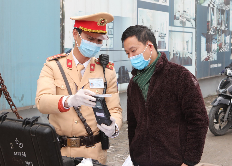 Cảnh sát giao thông Hà Nội sử dụng phương tiện an toàn kiểm tra nồng độ cồn trong khí thở đối với người tham gia giao thông. (Ảnh: Doãn Tấn/TTXVN)