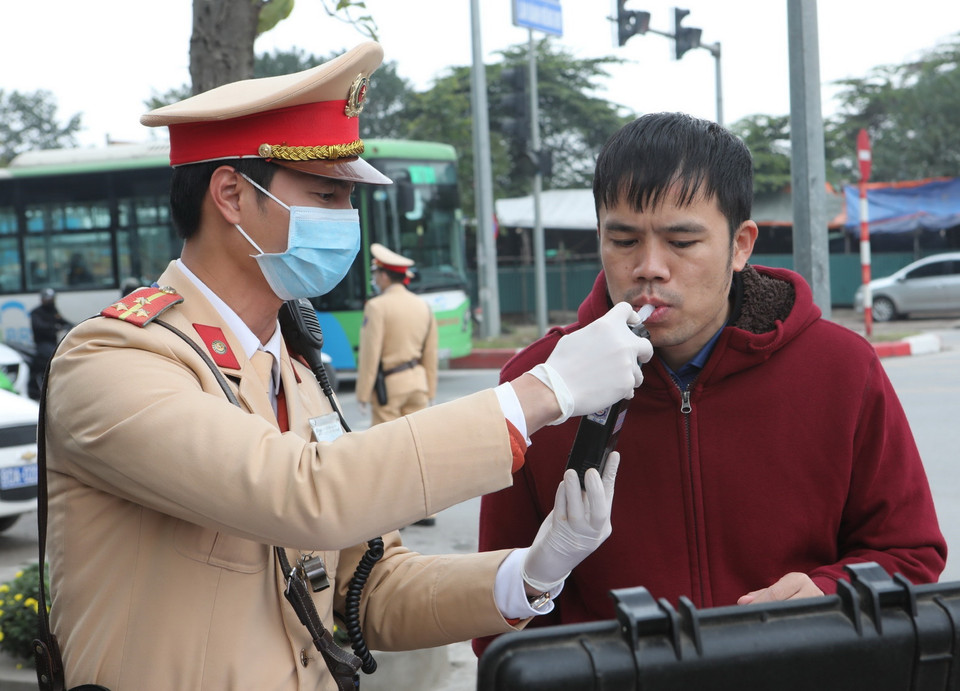 Trong ảnh: Cảnh sát giao thông Hà Nội sử dụng phương tiện an toàn kiểm tra nồng độ cồn trong khí thở đối với người tham gia giao thông. (Ảnh: Doãn Tấn/TTXVN)