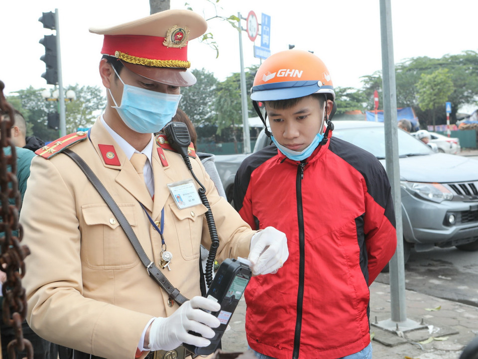 Cảnh sát giao thông Hà Nội sử dụng phương tiện an toàn kiểm tra nồng độ cồn trong khí thở đối với người tham gia giao thông. (Ảnh: Doãn Tấn/TTXVN)