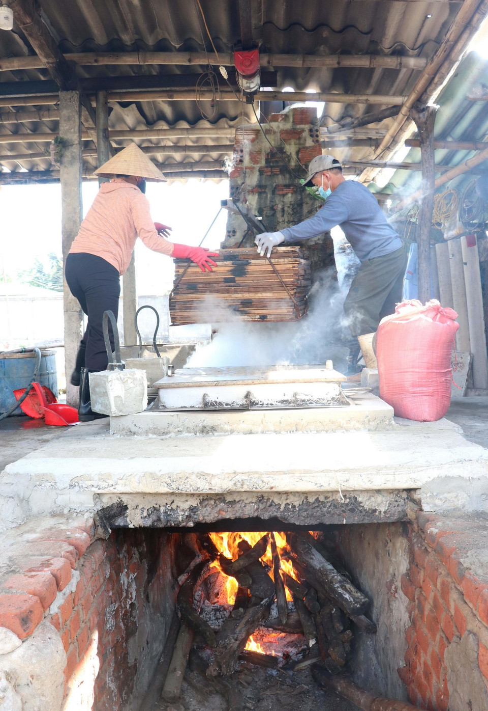  Đưa những vỉ cá cơm vào lò hấp. (Ảnh: Nguyên Lý/TTXVN)