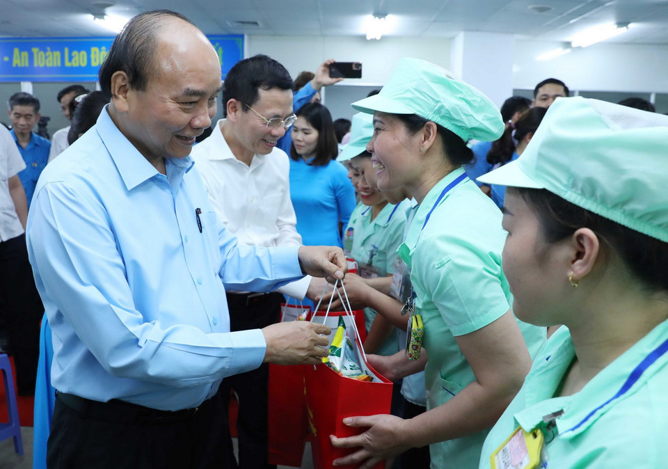 Thủ tướng Nguyễn Xuân Phúc tặng quà cho công nhân Công ty TNHH Điện tử Foster (Việt Nam). (Ảnh: Thống Nhất/TTXVN)