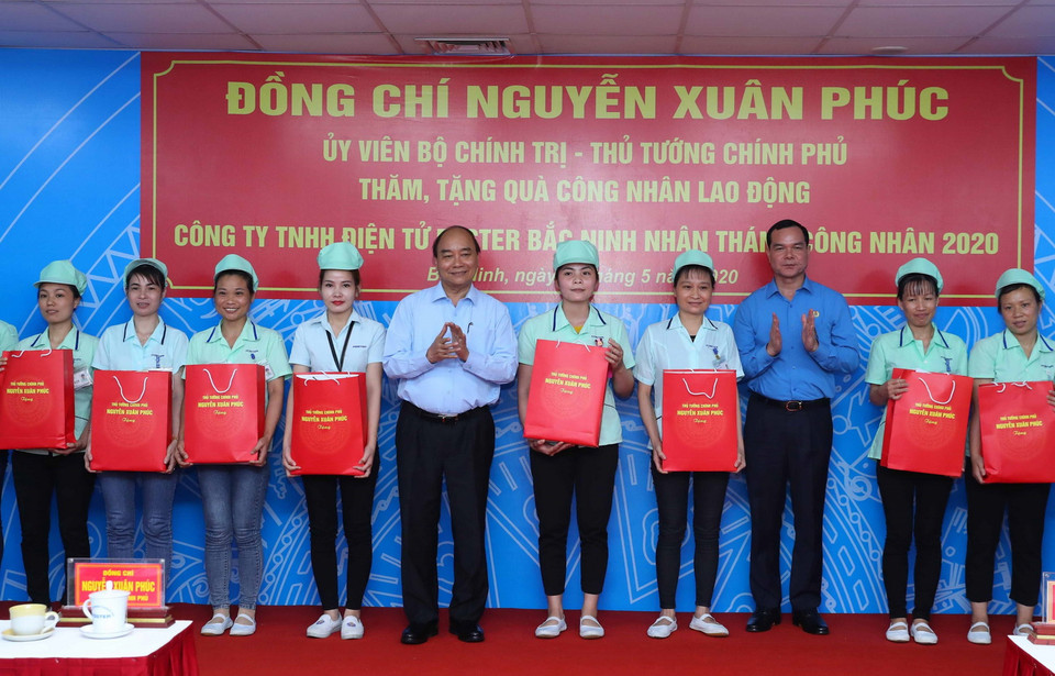 Thủ tướng Nguyễn Xuân Phúc tặng quà cho công nhân Công ty TNHH Điện tử Foster (Việt Nam). (Ảnh: Thống Nhất/TTXVN)