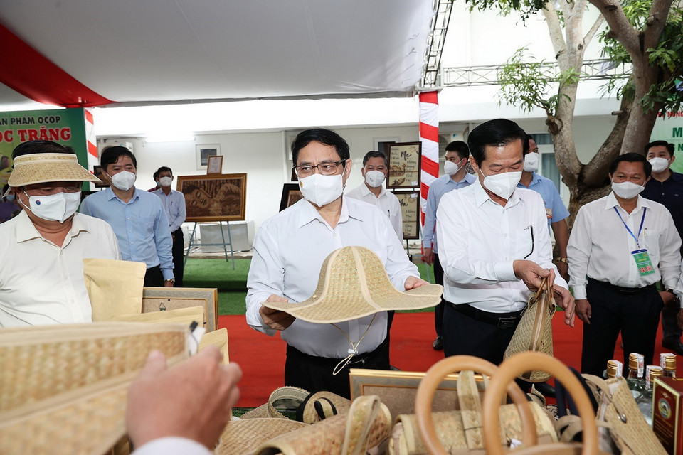 Thủ tướng Phạm Minh Chính xem các sản phẩm nông nghiệp. (Ảnh: Dương Giang/TTXVN)