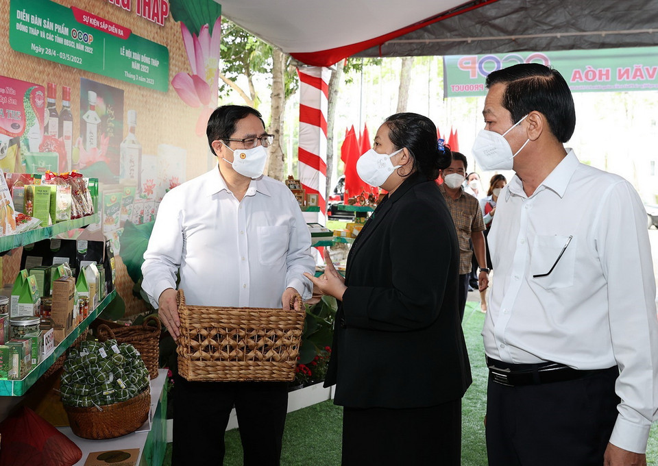  Thủ tướng Phạm Minh Chính trao đổi về các sản phẩm nông nghiệp. (Ảnh: Dương Giang/TTXVN)