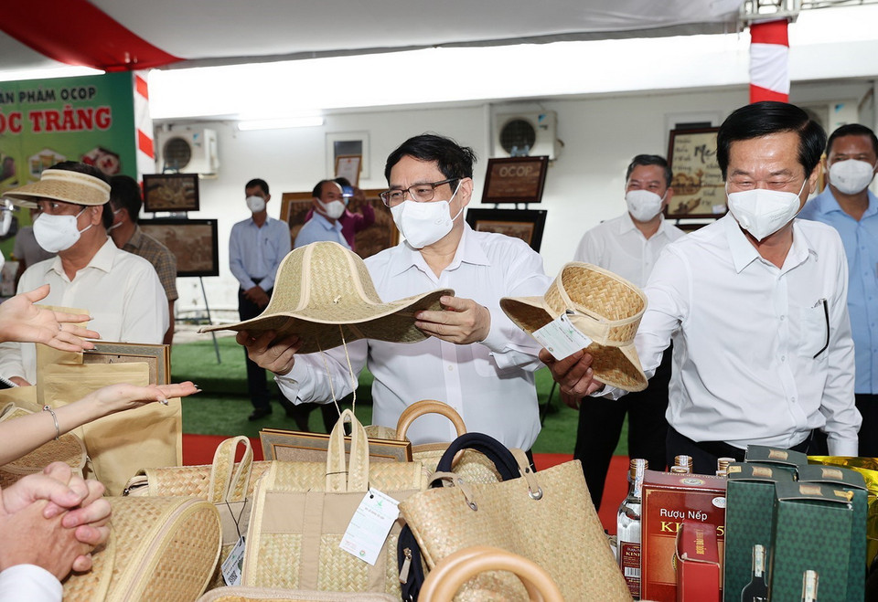 Thủ tướng Phạm Minh Chính xem các sản phẩm thủ công trưng bày. (Ảnh: Dương Giang/TTXVN)
