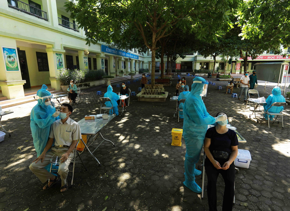 Người dân phường Nghĩa Đô được lấy mẫu xét nghiệm COVID-19. (Ảnh: Vũ Sinh/TTXVN)