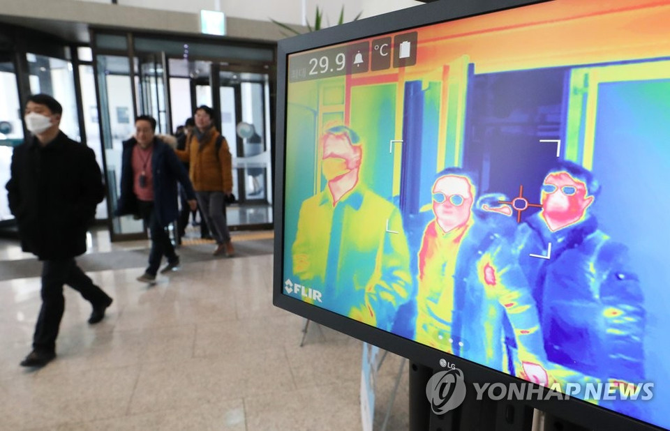 Kiểm tra thân nhiệt những người đến làm việc tại khu văn phòng chính phủ tại Sejong, Seoul. (Nguồn: Yonhap)