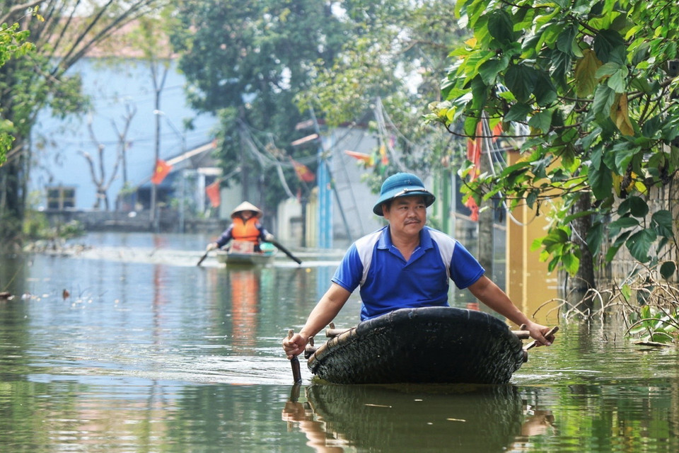 Người dân tranh thủ về nhà chăm sóc gia súc, gia cầm do không kịp di chuyển (ảnh chụp sáng 15/9). (Ảnh: Tuấn Anh/TTXVN)