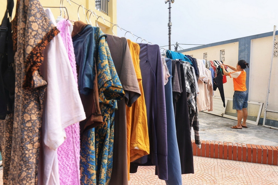 Người dân tranh thủ phơi quần áo tại nơi tập trung di dân vùng an toàn (ảnh chụp sáng 15/9). (Ảnh: Tuấn Anh/TTXVN)