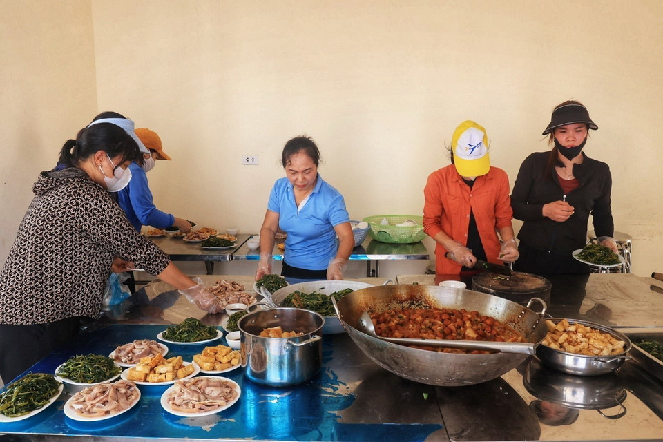 Các cô giáo trường Mầm non Nam Phương Tiến hỗ trợ nấu cơm cho người dân tại điểm tập trung an toàn (ảnh chụp sáng 15/9). (Ảnh: Tuấn Anh/TTXVN)