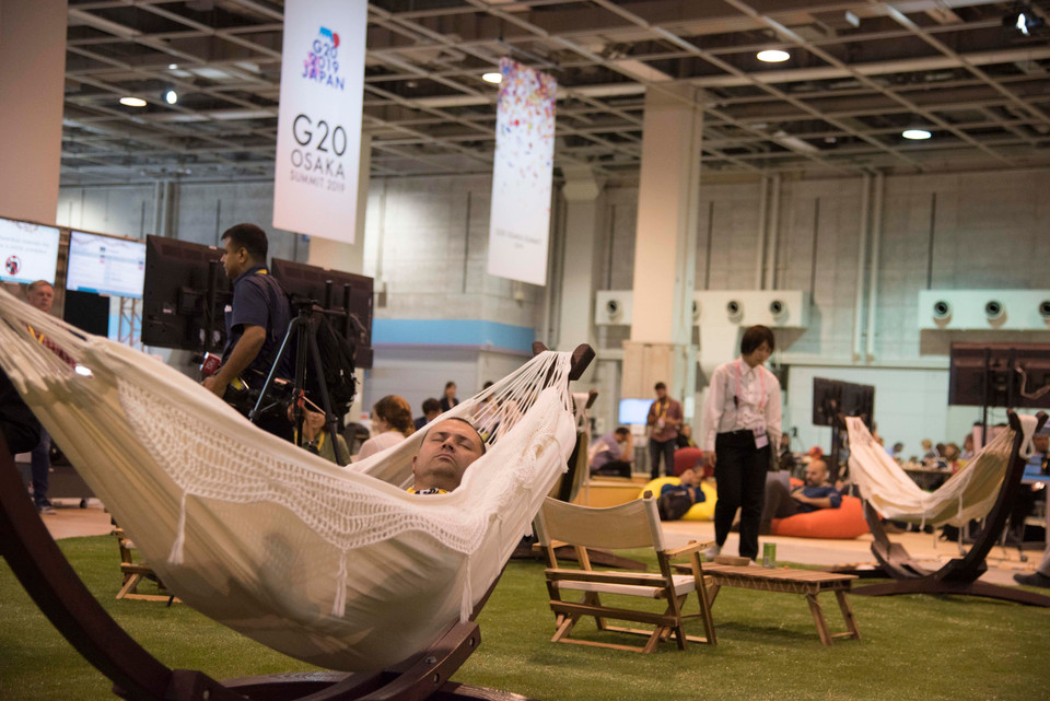 Một phóng viên đang nằm nghỉ trên chiếc võng được ban tổ chức bố trí tại Trung tâm báo chí, Hội nghị Thượng đỉnh G20, Osaka, Nhật Bản. 