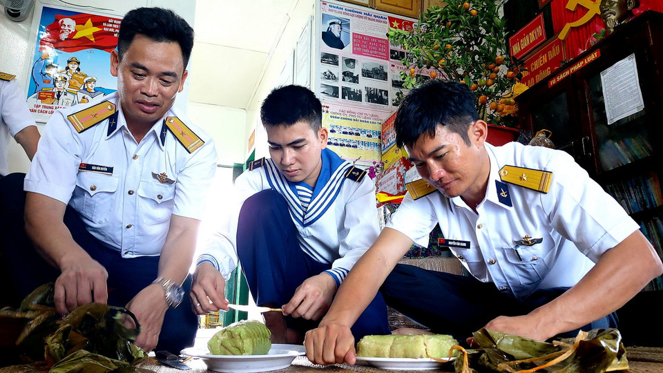 Cán bộ, chiến sỹ Nhà giàn DK1/10 cắt bánh chưng, bánh tét ăn Tết sớm. (Ảnh: Thu Hiền/TTXVN)