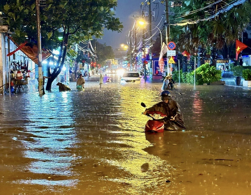 Đến gần 20 giờ, đường Bình Chiểu, thành phố Thủ Đức vẫn lênh láng nước. (Ảnh: Hồng Giang/TTXVN)