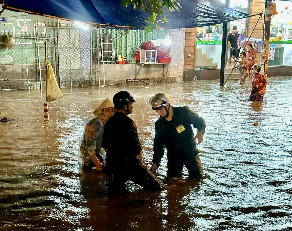 Đội hình phản ứng nhanh Chi đoàn Quân sự và Công an phường Bình Chiểu, thành phố Thủ Đức, khai thông các hố ga thoát nước trên tuyến đường Bình Chiểu. (Ảnh: Hồng Giang/TTXVN)