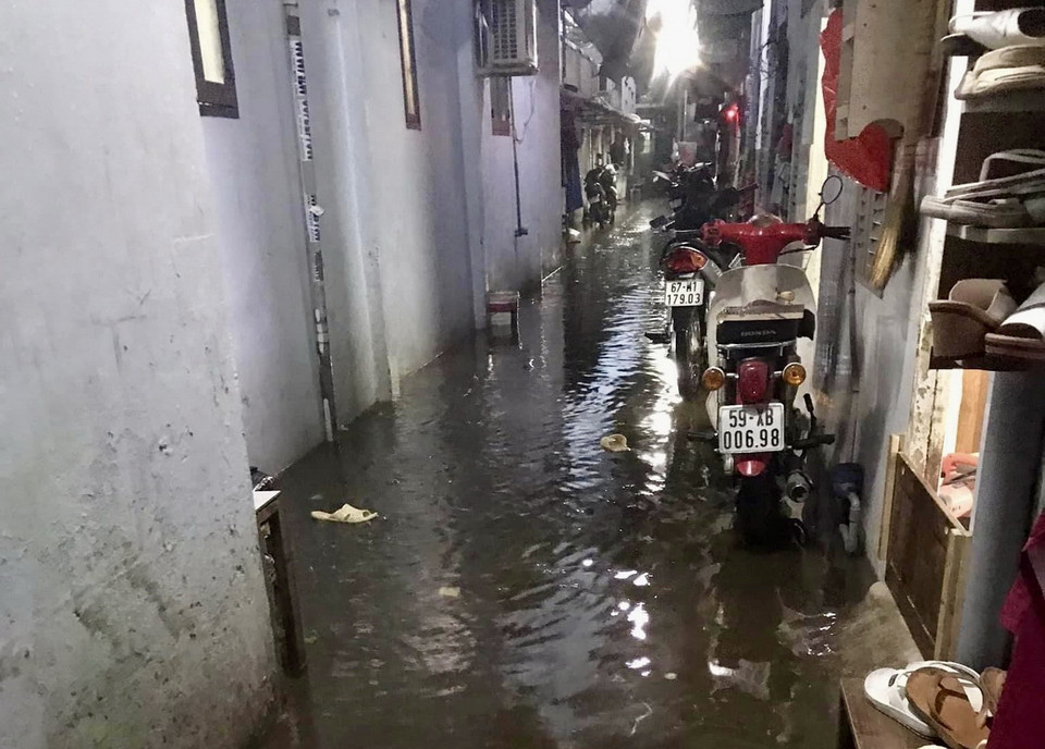 Nước ngập lênh láng tại một tuyến hẻm trên đường Đặng Thị Rành (thành phố Thủ Đức, Thành phố Hồ Chí Minh). (Ảnh: Hồng Giang/TTXVN)