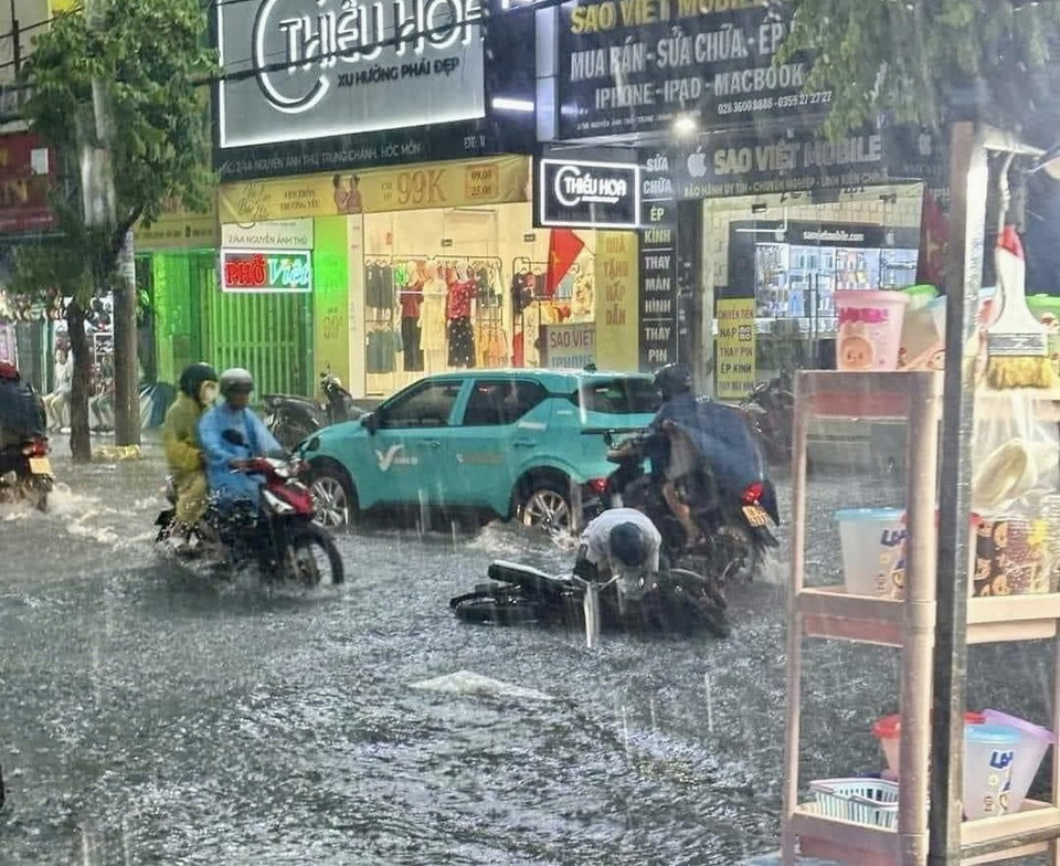 Nước ngập sâu khiến nhiều người dân bị té ngã. (Ảnh: TTXVN phát)