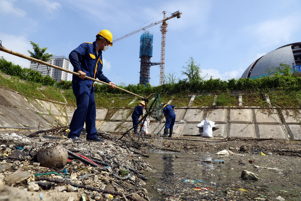 Công nhân Công ty Thoát nước vớt rác thải tại hồ điều hòa Yên Hòa, quận Cầu Giấy. (Ảnh: Huy Hùng/TTXVN)