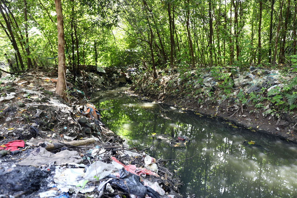 Nhiều đoạn cống nổi trên địa bàn quận Cầu Giấy bị rác thải sinh hoạt và xây dựng vùi lấp. (Ảnh: Huy Hùng/TTXVN)