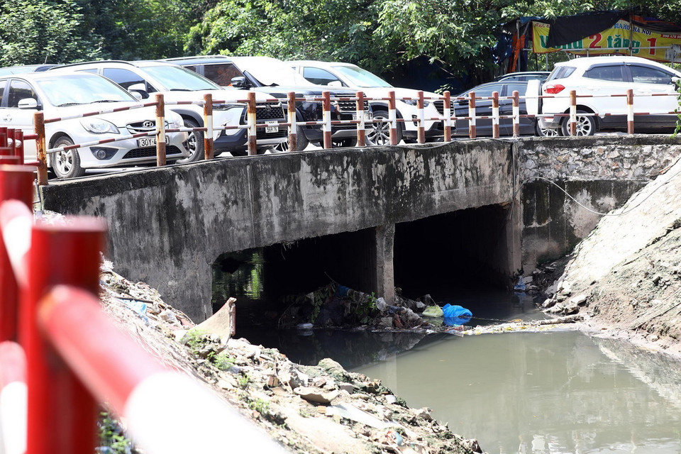 Một đoạn cửa cống bị rác thải đọng lâu ngày khiến dòng chảy bị ảnh hưởng đáng kể khi mưa to.(Ảnh: Huy Hùng/TTXVN)